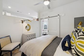 a bedroom with a bed and a dresser and a door to a bathroom at Link Apartments® Broad Ave, Memphis, TN